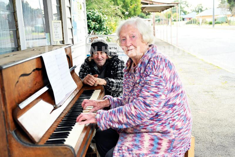 Footpath dischord ... Joan Ansell plays a tune in Tarnagulla for Trevor McDougall. LH PHOTO