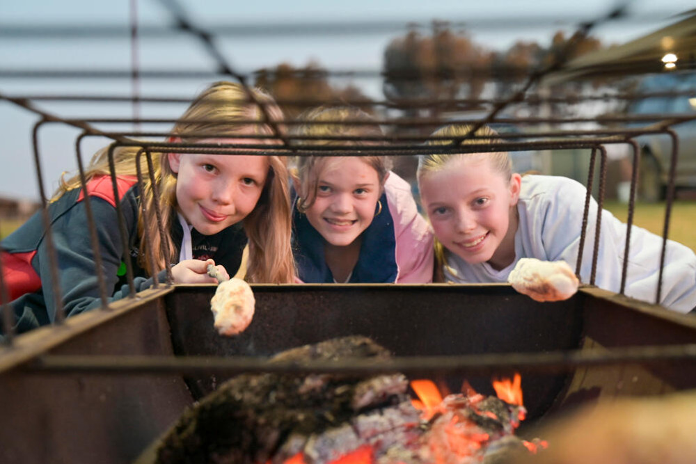 MARSHMALLOWS turned golden brown and warmed Abby Smith, Penny Balic and Talia Smith at Friday night’s community bonfire in Yarrawalla. They also tried their hands at damper making as district residents came togther for a local night out.