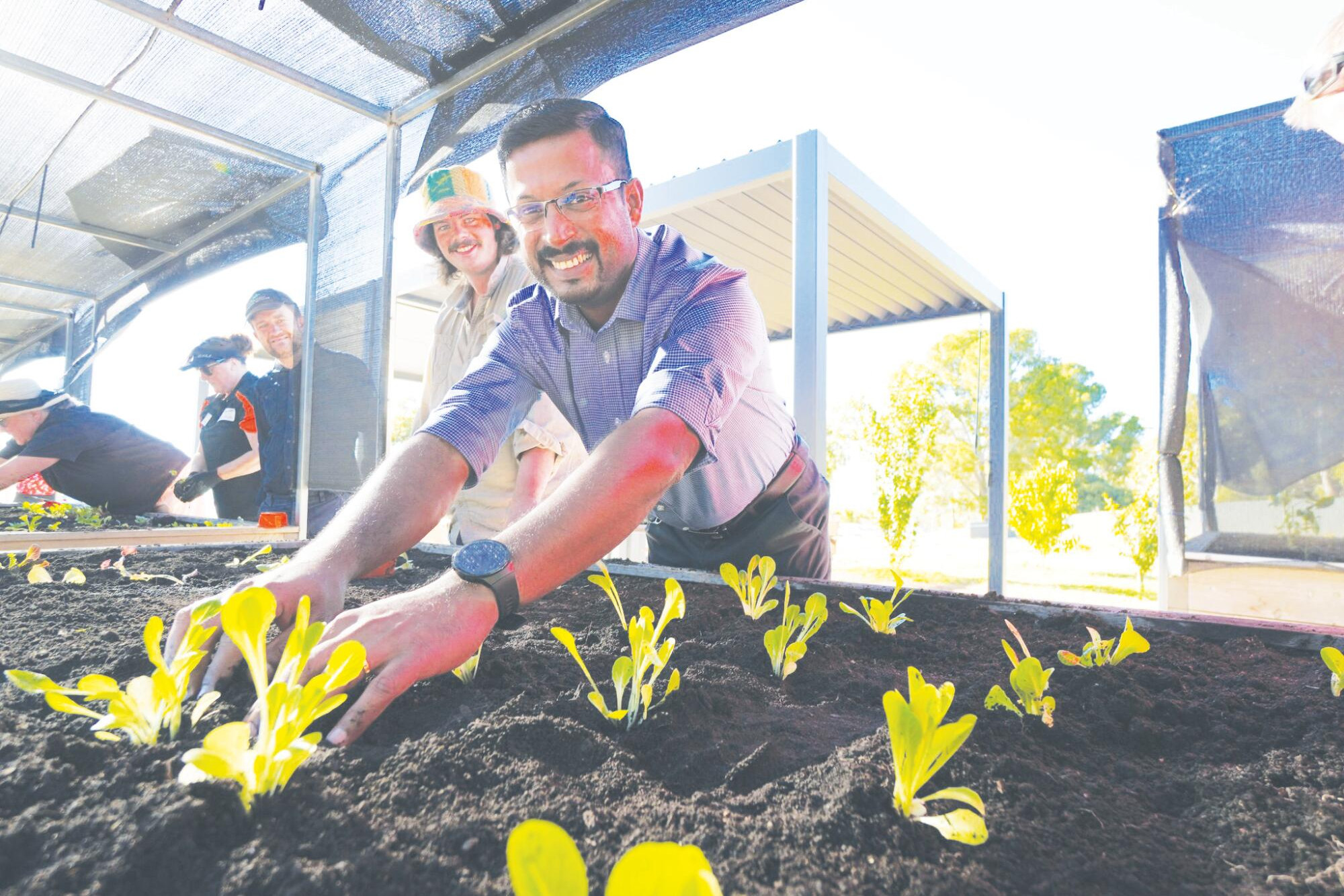Sibin Charly joins the community effort planting seedlings at the Boort District Health community garden.