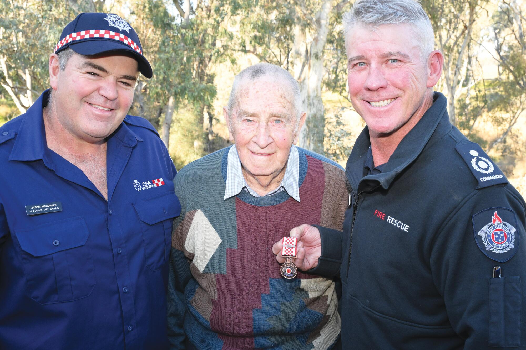 Captain Jason McDonald (left) and CFA’s Darren Crawford with ex-captain and 65-year member Ray Kelly