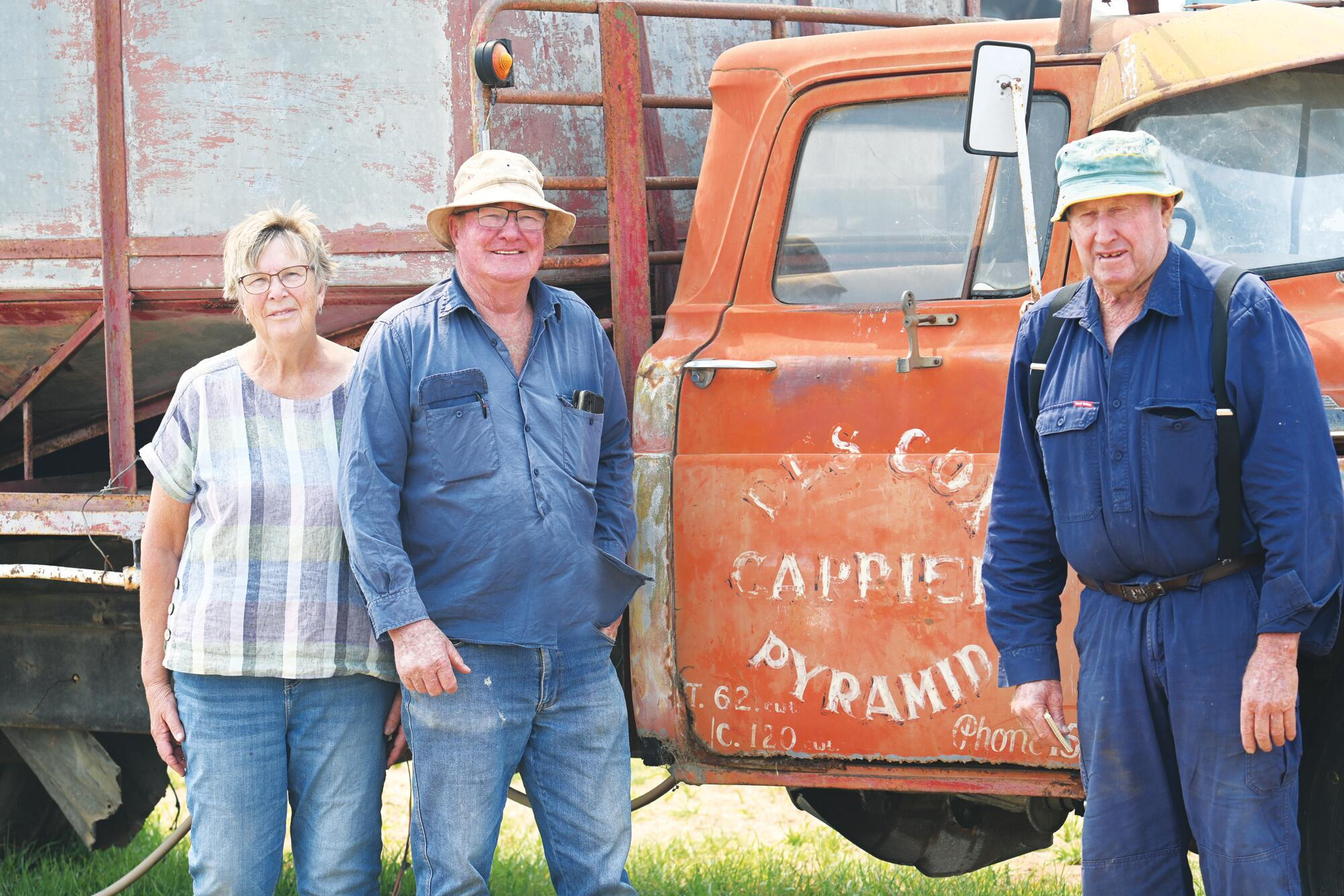 Terry Stobsaus, Peter Reynolds and Peter Meighan at Friday’s clearing sale beside the old truck bearing the Cox family name on the driver’s door. LH PHOTO