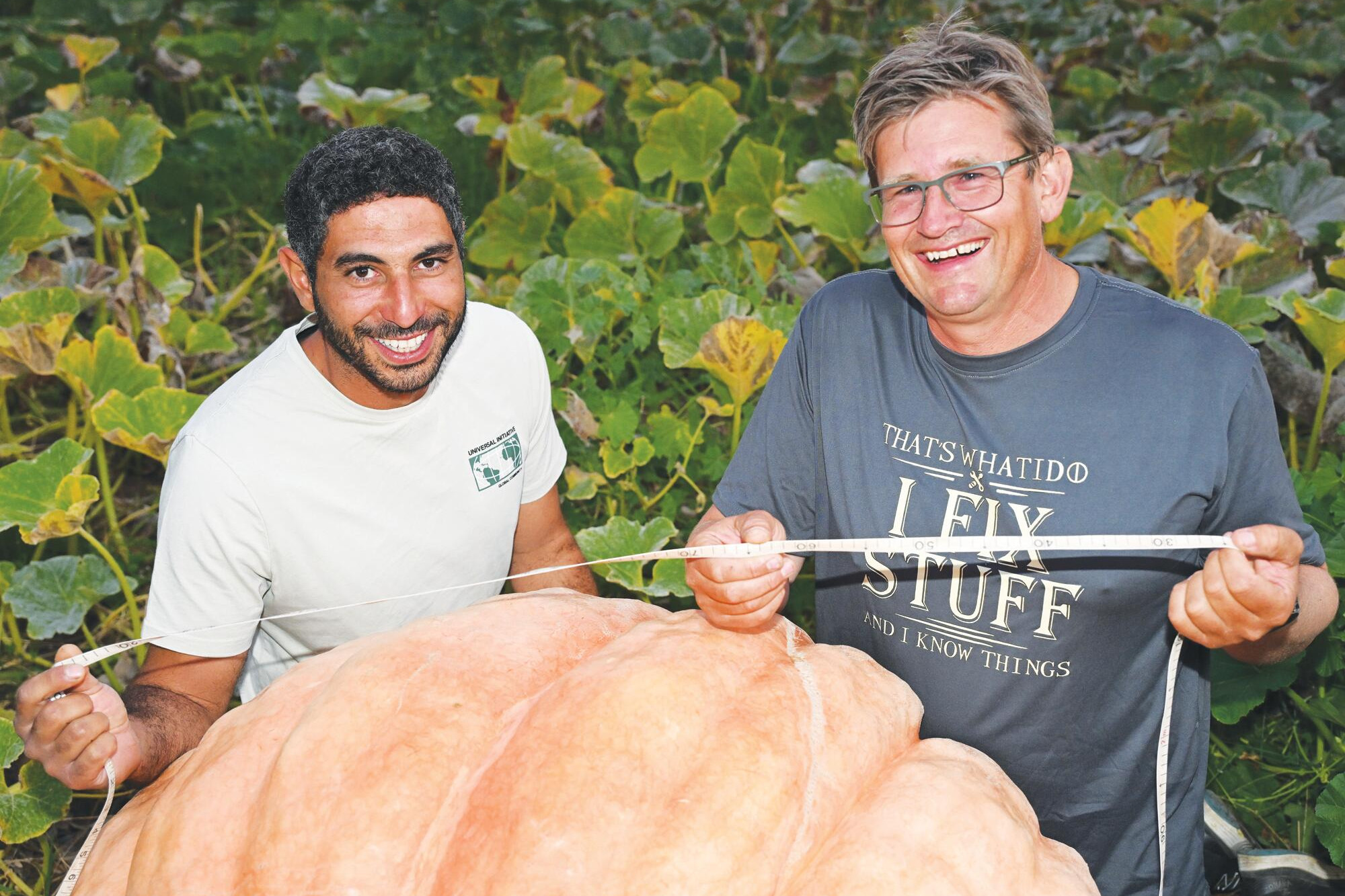 Fred Assi and Bradley Haw check the weight of the pumpkin to be paddled down the Murray River. LH PHOTO