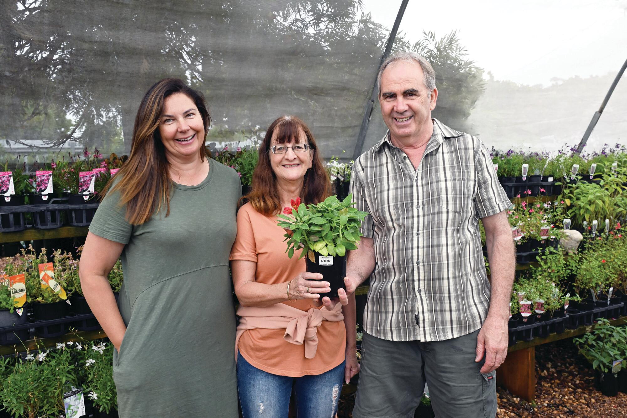 Bianca Rothacker assists birthday sale shoppers Dianne Moon and John Ritchie. LH PHOTO