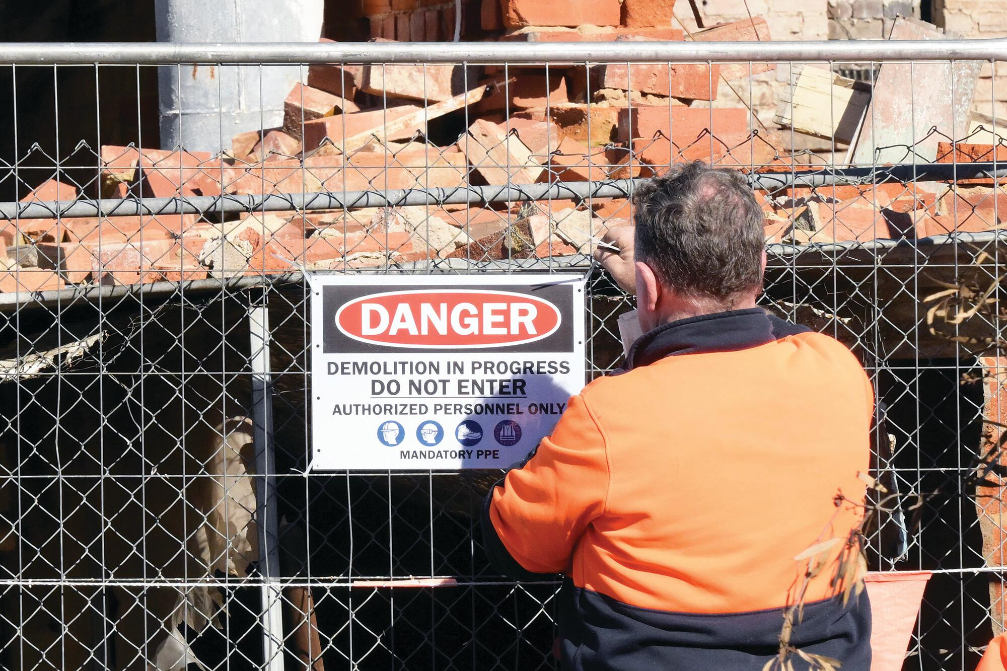 Demolition signs are tied to the safety fence