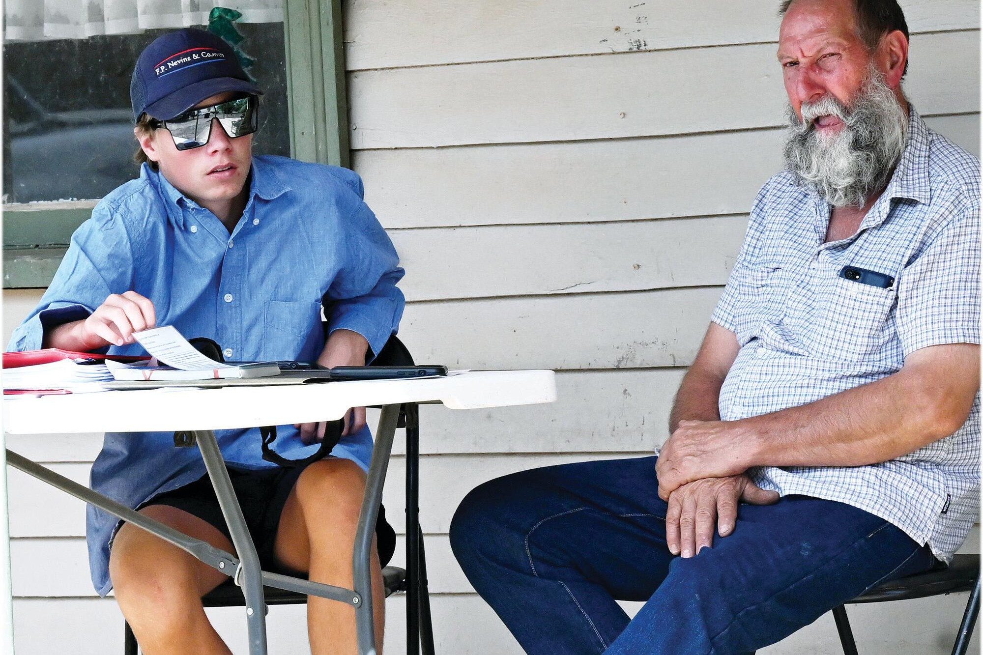 Nevins’ Nicholas Pickering chats with Gary Perry before last Thursday’s auction. LH PHOTO