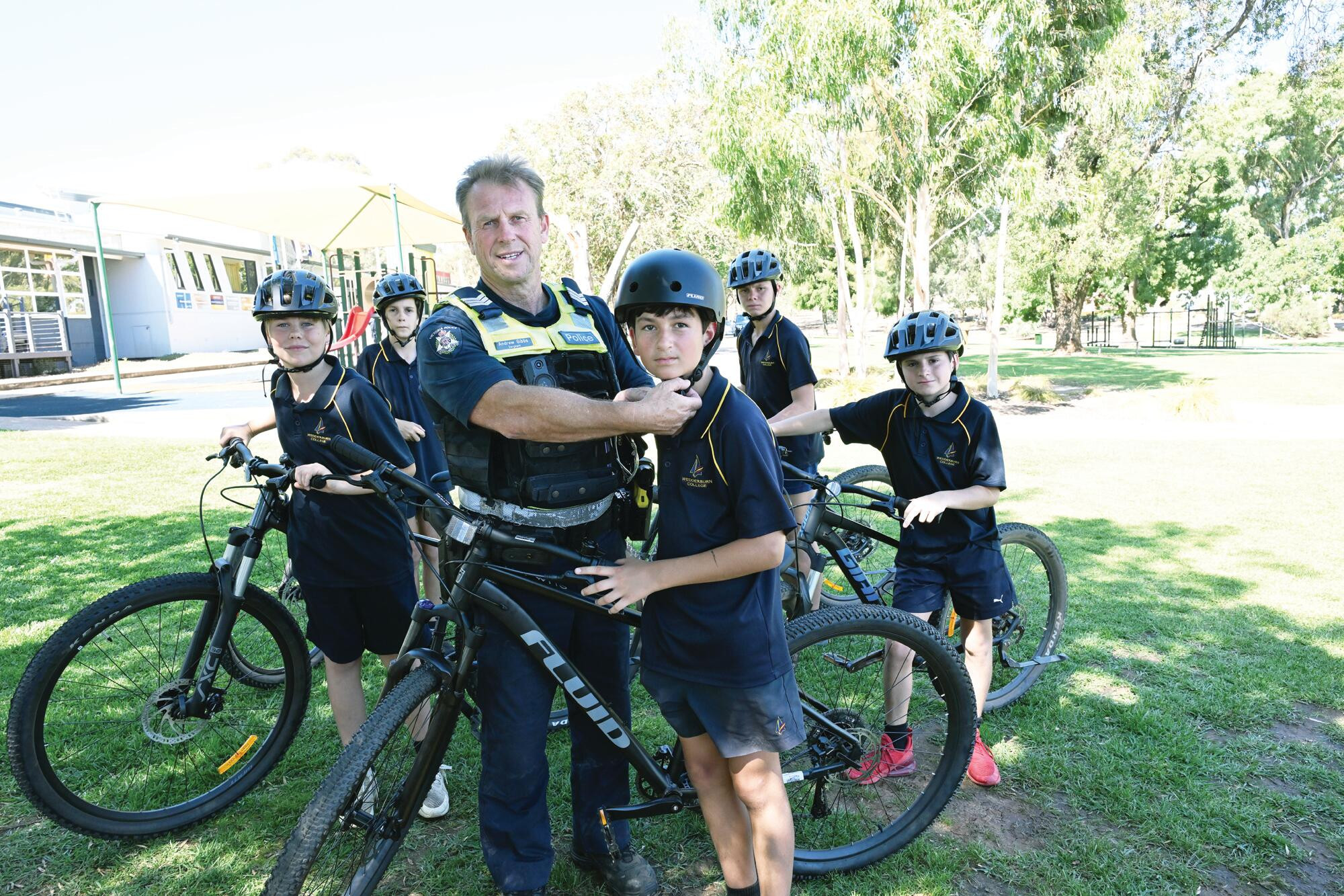 Sgt Andy Gibbs adjusts the helmet of Wedderburn College’s Luke Martin and shares tips for Will Baldwin, Logan Tucker, Brodie Turnbull and Wade Collins as police and the school encourage safe cycling. LH PHOTO