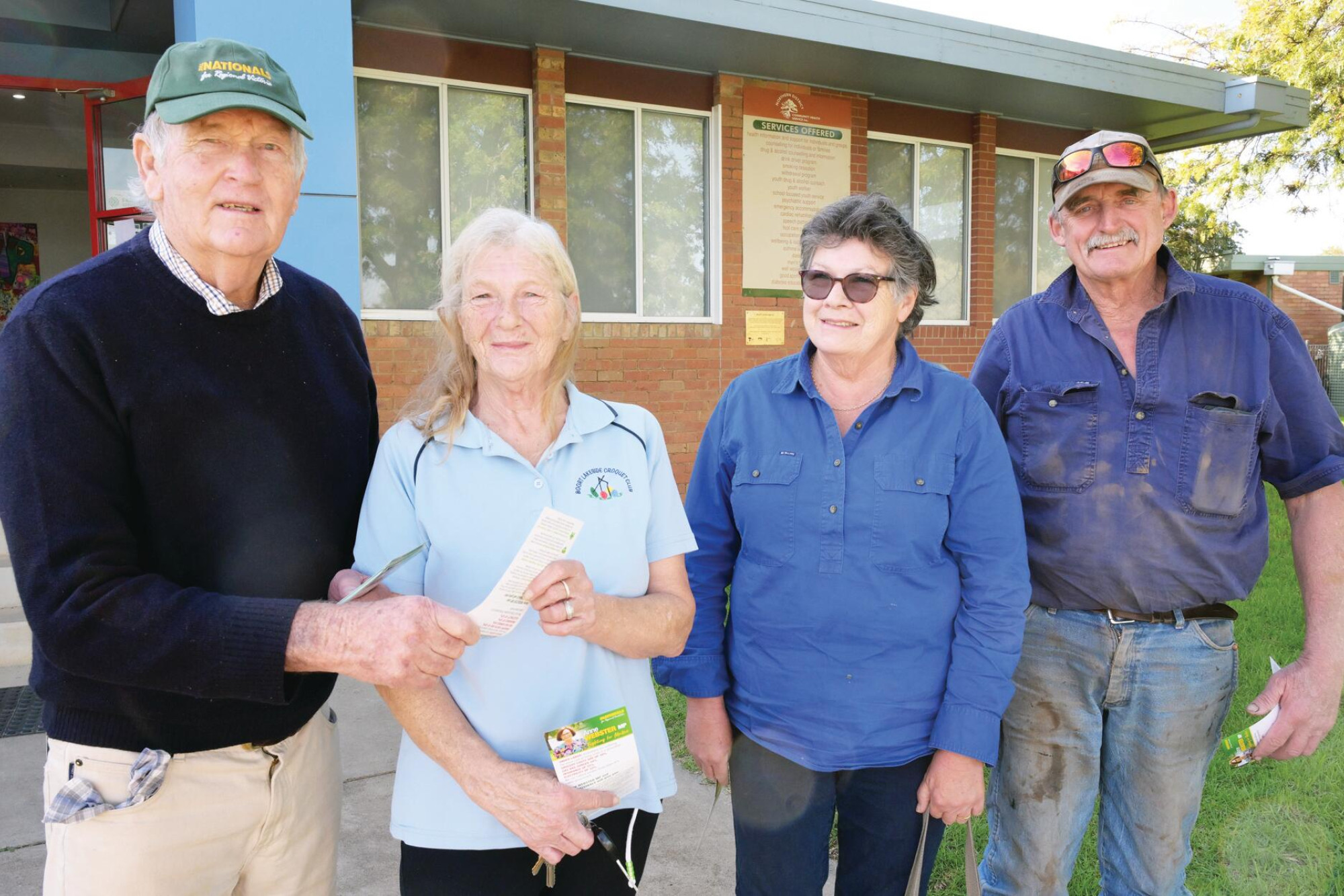 Bruce Malone hands how-to-vote cards to Sue Soltan, Amanda and Alan Wilson at Boort. LH PHOTO