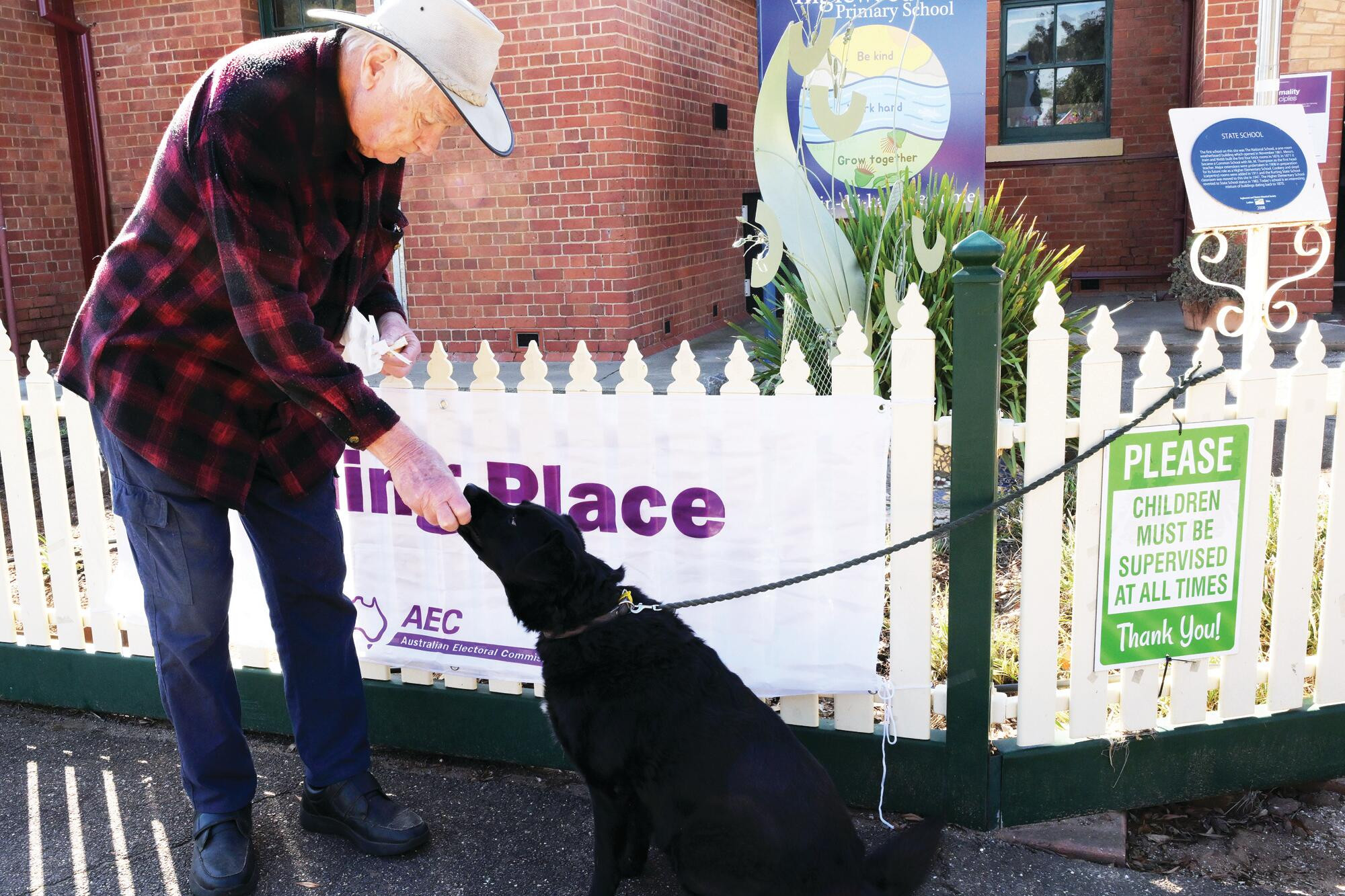 Damien Bennetto and Millie share their Democracy Sausage outside the Inglewood booth. LH PHOTO